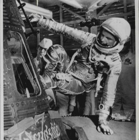 Astronaut John Glenn swings himself carefully through the hatch of his Friendship Seven space capsule.