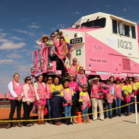 Gina Rinehart and her team standing alongside a pink locomotive.