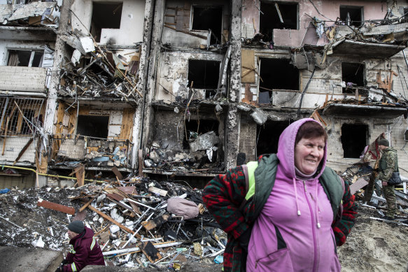 People react to the damage following a rocket attack on a residential building in Kyiv, Ukraine.