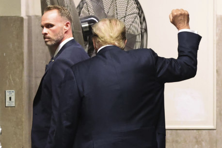 Guilty: Donald Trump raises a clenched fist as he leaves court.