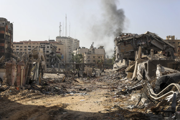 Palestinians walk through destruction in Gaza City last Friday, as the temporary ceasefire between Israel and Hamas took effect.