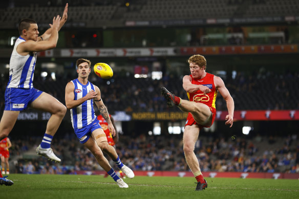 Gold Coast’s Matt Rowell kicks the ball under pressure from Luke Davies-Uniacke.