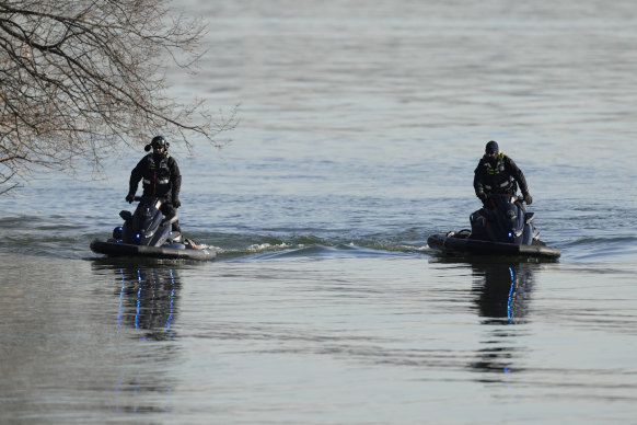 Rescuers search the wreckage site in the Potomac River near Ronald Reagan Airport.