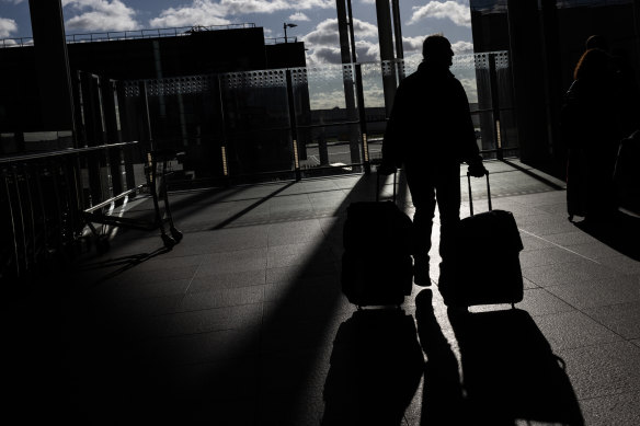 A passenger pulls his luggage as he departs Heathrow Airport in London.