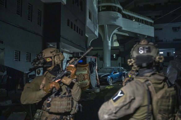 Israeli soldiers from the 7th Brigade escort journalists on the grounds of the Al-Shifa Hospital in Gaza City.