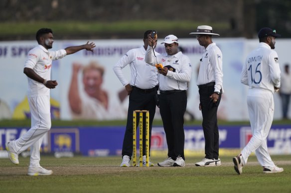 Umpire Nitin Menon checks the light with fellow umpires Kumar Dharmasena, right, and Raveendra Wimalasiri during day two of the first Test in Galle.