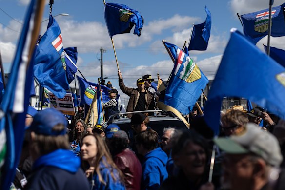 Apoiadores hasteiam bandeiras em apoio a Mitch Sylvestre enquanto ele submete suas assinaturas para um referendo de separação nas eleições de Alberta, em Edmonton, no início de maio.
