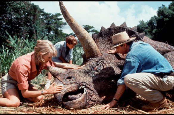 Neill tends to an ailing triceratops with Laura Dern in Jurassic Park (1993).