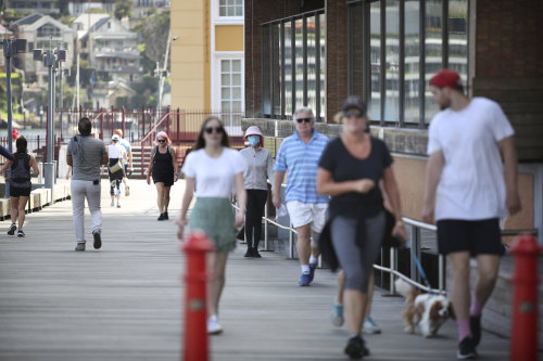 Walkers stroll by Luna Park earlier this month. The park has been closed due to the coronavirus outbreak since mid-March. 