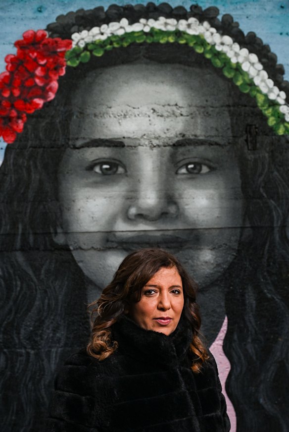 Director Kaouther Ben Hania with a mural of Hind Rajab.