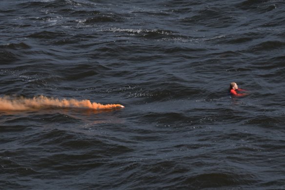 The helicopter released an orange smoke canister near the woman to help direct rescue boats to her. 