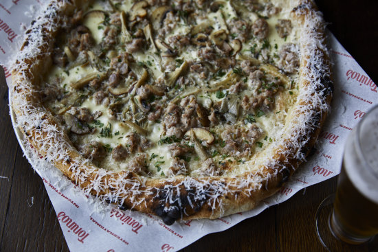 Boscaiolo pizza with pork sausage, mushrooms, garlic cream and grana padano cheese.