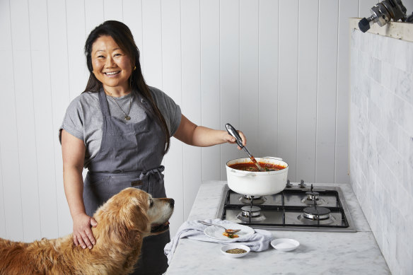 RecipeTin Eats founder and owner Nagi Maehashi cooking under the watchful eye of Dozer.