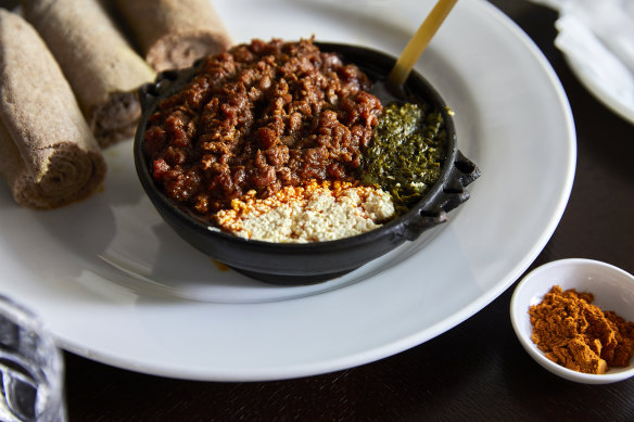 Special kitfo - finely chopped, spiced raw beef with gomen (sauteed kale) and ayip (Ethiopia’s answer to cottage cheese).