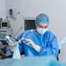A nurse prepares a medical instrument for performing a hysteroscopy operation.