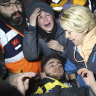 Rescuers and mother surround Adnan Mohammet Korkut after he was rescued in Gaziantep, southern Turkey, early on Friday.