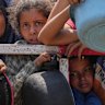 Palestinians struggle to get donated food at a community kitchen, in Gaza City, northern Gaza Strip, on Saturday, July 26.