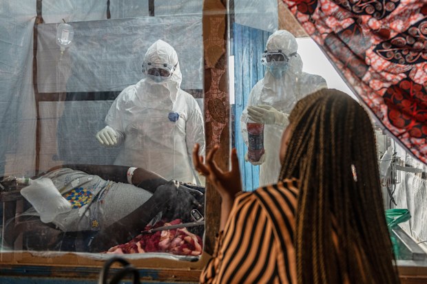 Health workers attend to an Ebola patient at the Rwampara treatment Center in Ituri, Congo.