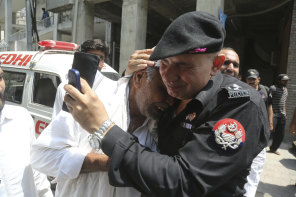 A police officer comforts a man who lost a relative in suicide bomb attack in Lahore in 2019. 