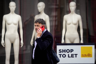 A man walks past a closed shop in London. The Bank of England has projected the UK will enter a recession at the end of the year. 