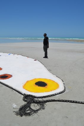 Daniel Walbidi installing "Wirnpa", one of the artworks in the exhibition.