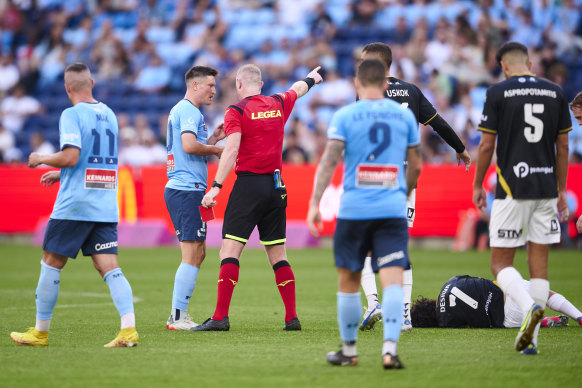 Joe Lolley of Sydney FC receives a red card for a tackle on Daniel DeSilva of Macarthur FC.