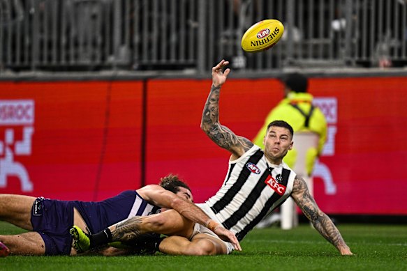 Jamie Elliott of the Magpies is tackled by Alex Pearce of the Dockers.