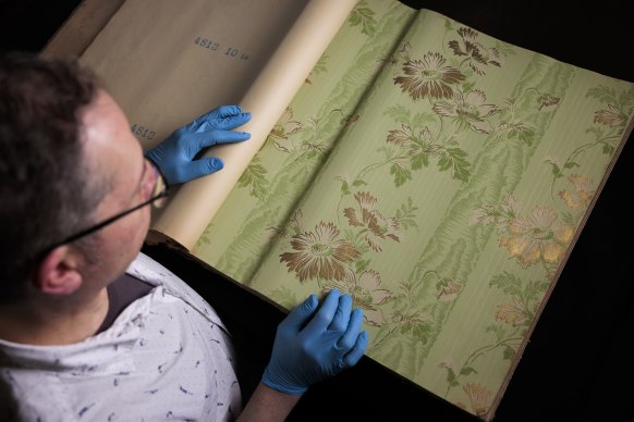 Museums of History NSW Michael Lech, with a selection from a massive collection of wallpaper that has been given to the museum.