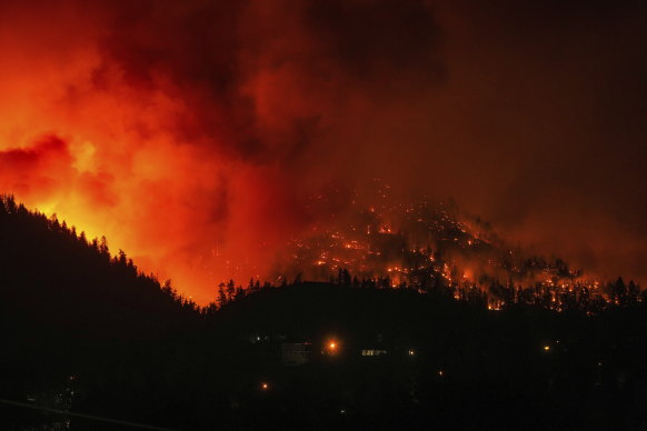 The McDougall Creek wildfire burns on the mountainside above houses in West Kelowna, Canada, in August.