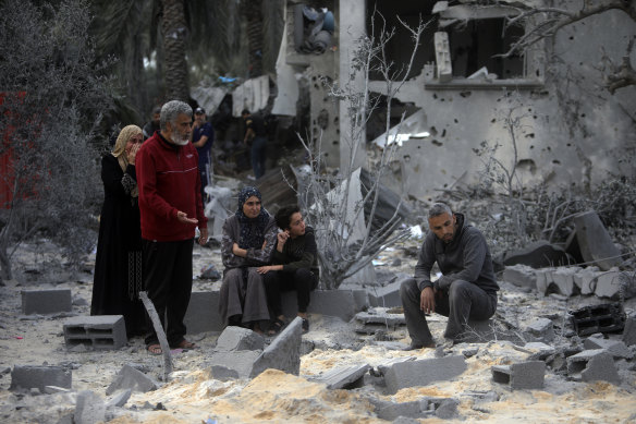 Palestinians sit in the rubble of a destroyed house following Israeli airstrikes on Khan Younis.