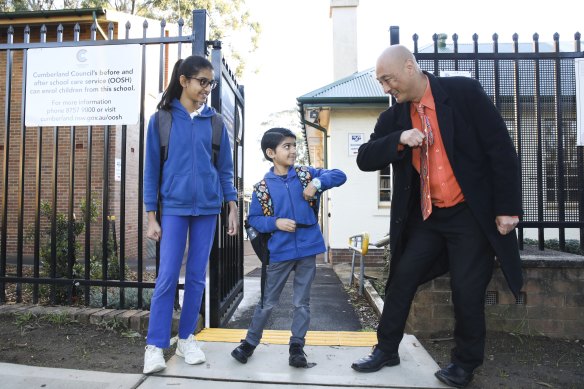 Merrylands East Primary School principal John Goh greets students Maitreyi and brother Yajat Patel at 7.30am.