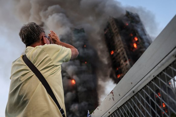 Wong watches his apartment building burn while his wife is inside.