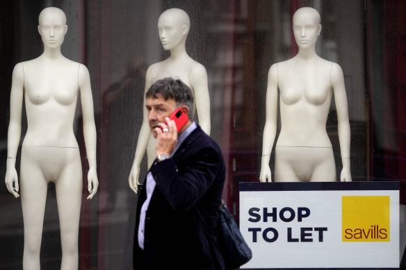 A man walks past a closed shop in London. The Bank of England has projected the UK will enter a recession at the end of the year. 