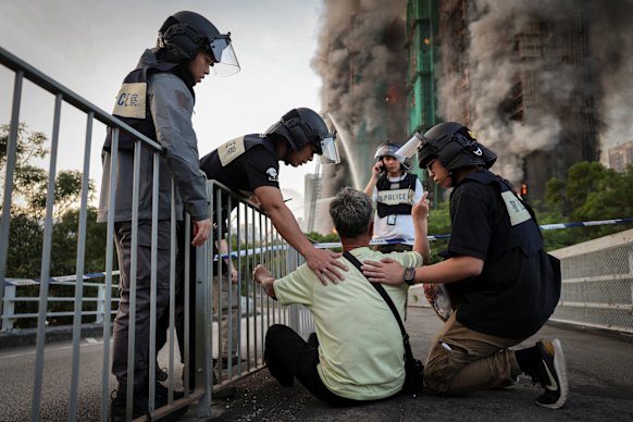 Police officers comfort Wong amid the Hong Kong blaze.