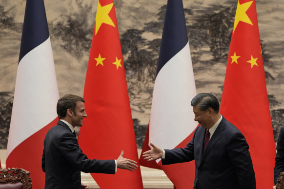 French President Emmanuel Macron, left, shakes hands with Chinese President Xi Jinping.