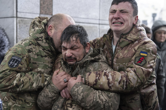Ukrainian servicemen cry near the coffin of their comrade Andrii Trachuk during his funeral service in Kyiv last month.