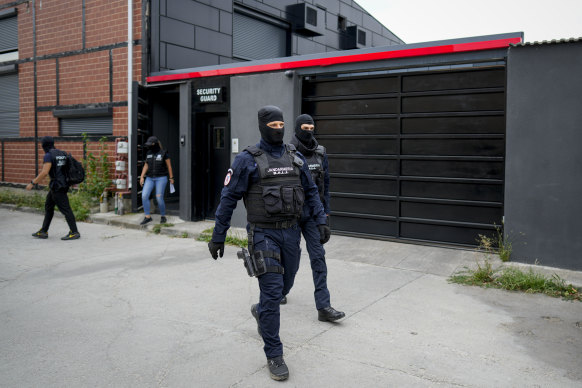 Gendarmes wearing balaclavas walk outside the residence of Andrew Tate during a police search raid, on the outskirts of Bucharest, Romania.