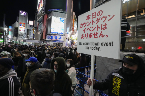 Security guards held up signs at Tokyo’s  famous Shibuya Crossing to warn off people trying to gather there.