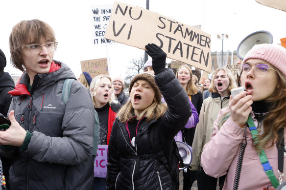 Climate activist Greta Thunberg, centre, attends a demonstration by youth-led organisation Aurora, in Stockholm, Sweden, in November. Her sign says “Now we sue the state”. 