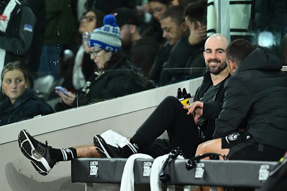 Collingwood midfielder Steele Sidebottom watches on after injuring his knee.