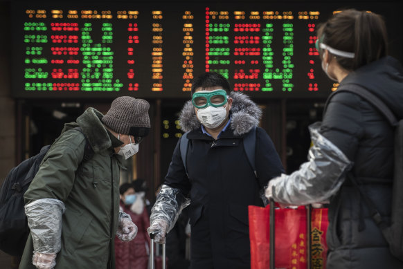Chinese travellers wear protective masks and goggles after getting off a train in Beijing.