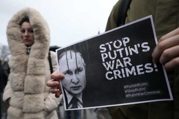 A man holds a banner showing a picture of Russian President Vladimir Putin during a protest against the Russian invasion and in solidarity with the Ukrainian people in Serbia on December 24.