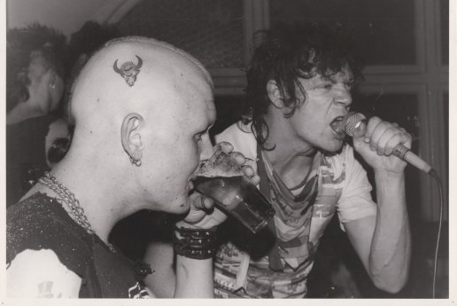 Fred Negro (with microphone) in 1984 performing with his band I Spit On Your Gravy next to a punk fan.