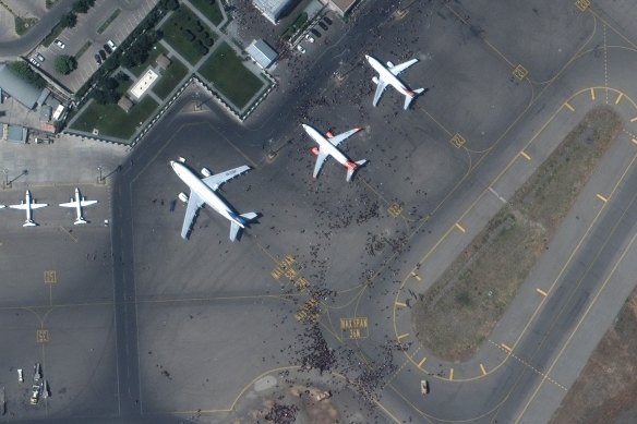 A satellite photo shows swarms of people on the tarmac at Kabul international airport on Monday.
