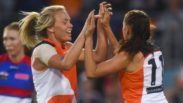 A team transformed: Aimee Schmidt of the Giants (right) celebrates kicking a goal against the Western Bulldogs.
