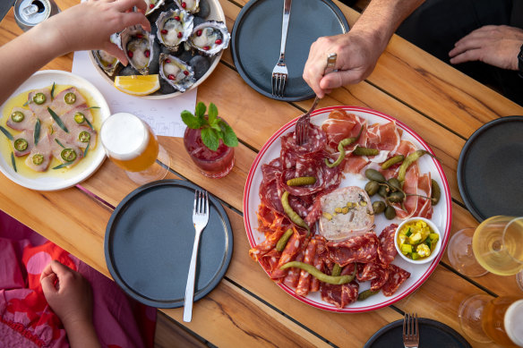 Kingfish sashimi, freshly shucked oysters with kampot pepper and a plate of Queen Vic Market deli meats at Brick Lane Market.
