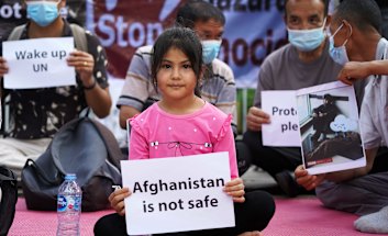 Afghan refugees gather outside the UNHCR office in Jakarta on Tuesday after a deadly bomb blast in Kabul. 