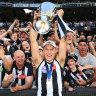 Collingwood captain Darcy Moore brandishes the cup to the Magpie army.