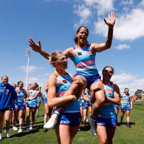 Richelle Cranston of the Bulldogs is chaired off the ground by teammates Isabelle Pritchard and Ellie Blackburn after announcing her retirement.