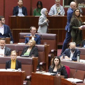 The moment Fatima Payman (in grey) crossed the floor in the Senate on Tuesday.